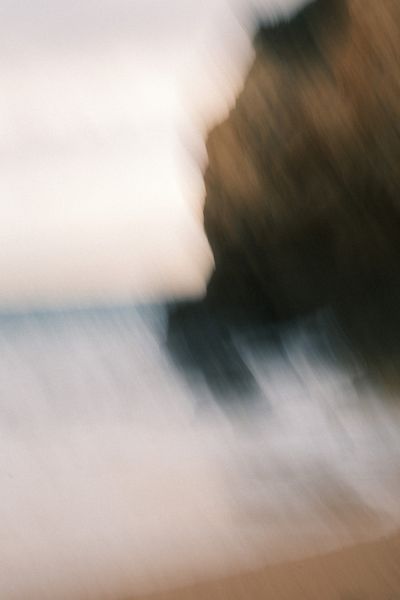 A blurry image of a wave crashing into a rock formation, shot in relatively close distance, near Albufeira, Portugal